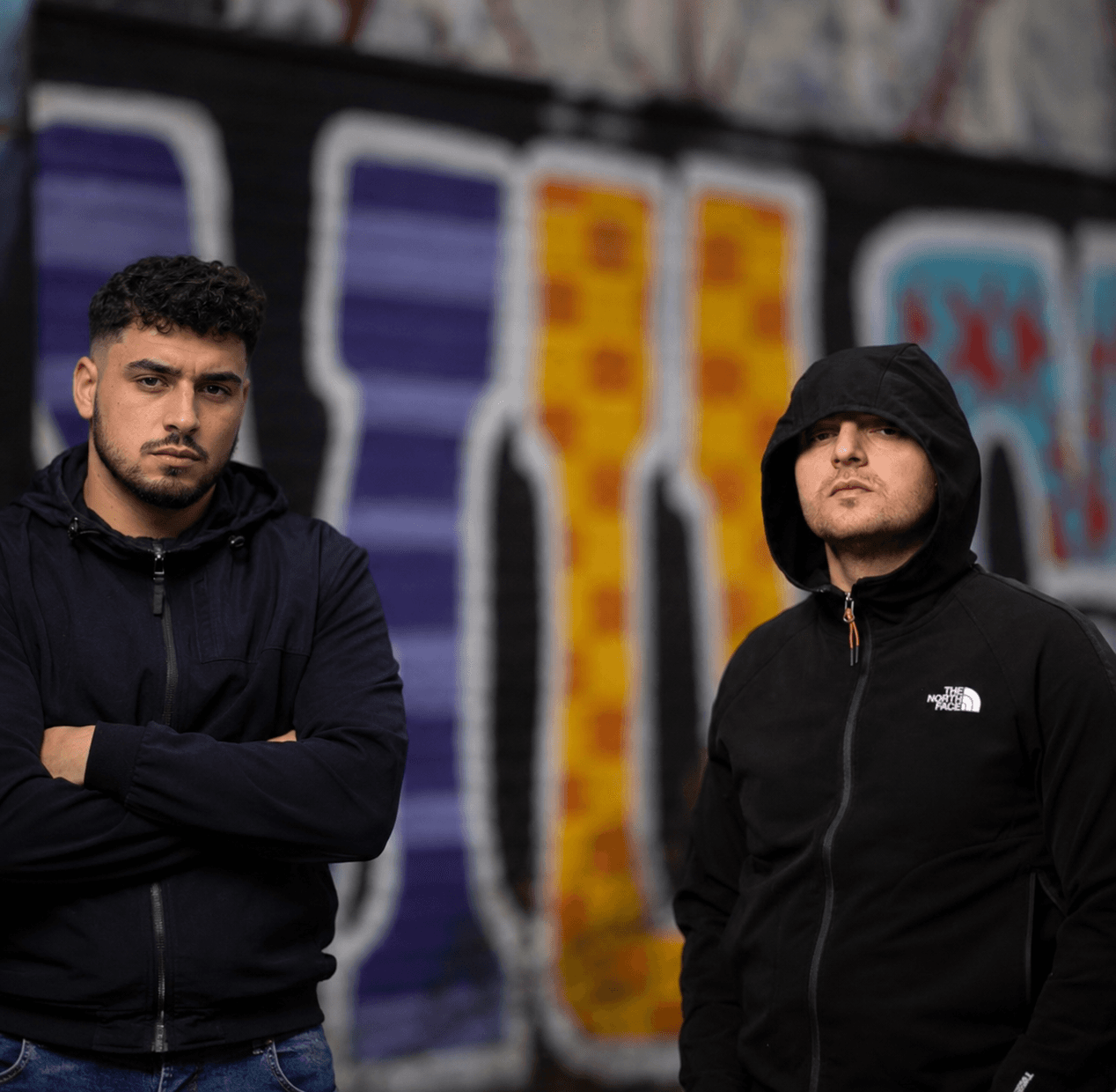 Twee jongeren voor een graffiti muur, representatief voor de leefwereld van jongeren en straatcultuur
