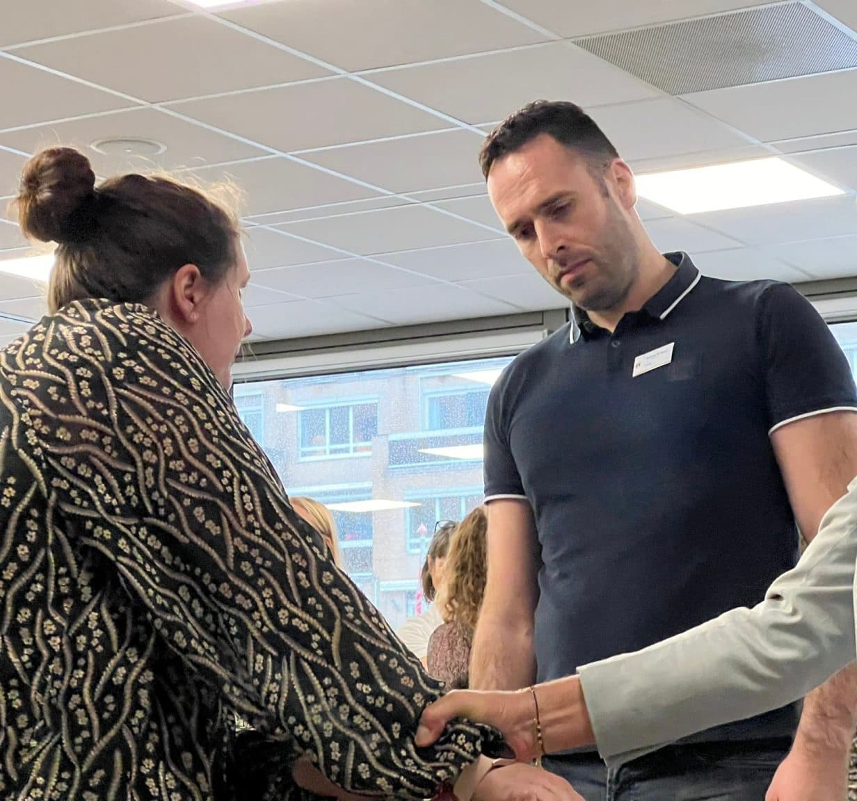 Trainer begeleidt deelnemers in een training fysieke weerbaarheid